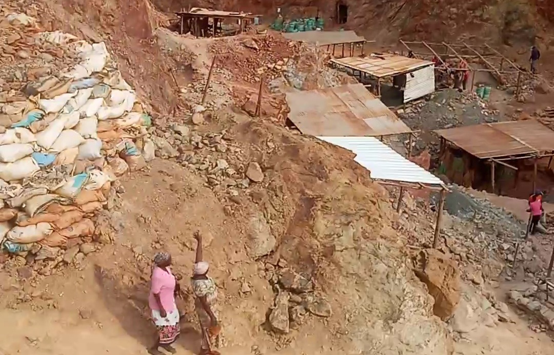car interior from central back seat position showing driver and blurred view through windscreen of a busy road at night